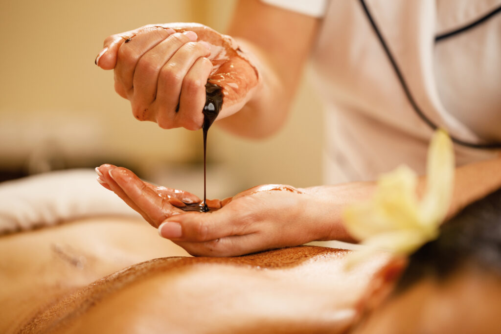 Close up of therapist preparing for hot chocolate massage at the spa.